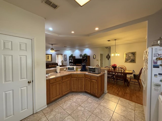 kitchen with ceiling fan with notable chandelier, light tile patterned floors, white refrigerator, and ornamental molding