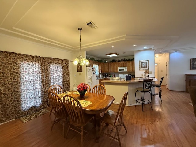 dining space featuring hardwood / wood-style floors and a chandelier