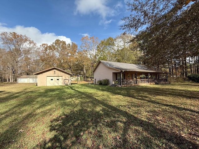 view of yard with an outbuilding, a porch, and a garage