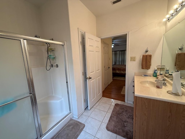 bathroom with tile patterned flooring, vanity, and walk in shower