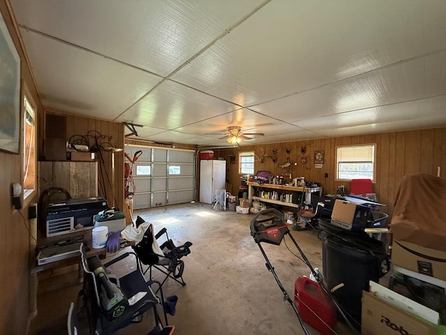 garage with a workshop area, ceiling fan, and wooden walls