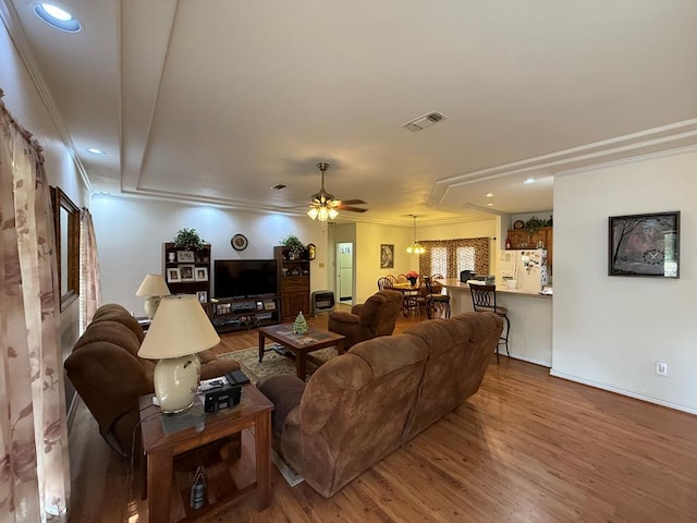 living room with ceiling fan, crown molding, and hardwood / wood-style flooring