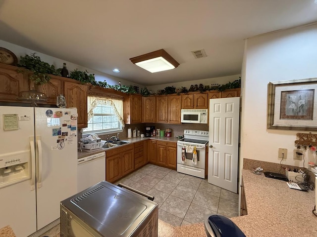 kitchen with white appliances, sink, and light tile patterned floors