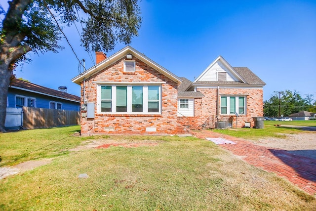 view of front of home with a front yard and central AC unit