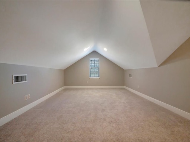 additional living space with light colored carpet and lofted ceiling