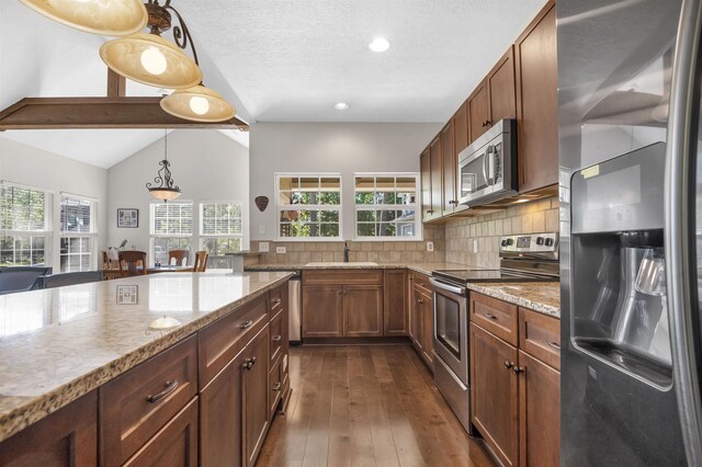 346 Northview Dr, Brookeland, TX 75931 - kitchen with appliances with stainless steel finishes, light stone counters, dark wood-style flooring, backsplash, and hanging light fixtures