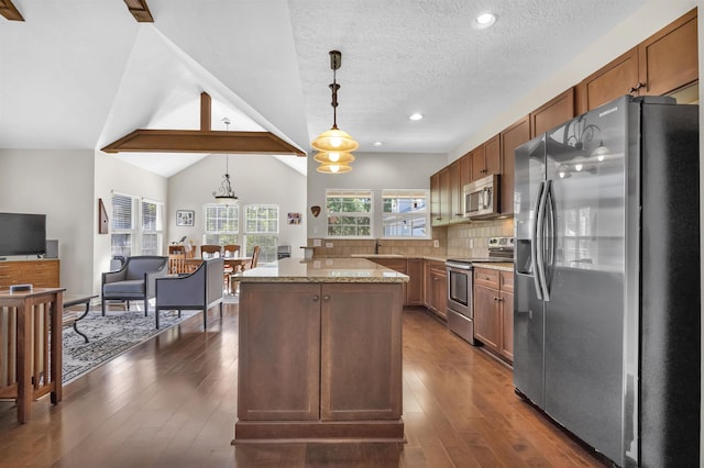 346 Northview Dr, Brookeland, TX 75931 - kitchen featuring stainless steel appliances, a center island, light stone counters, hanging light fixtures, and dark wood-style floors
