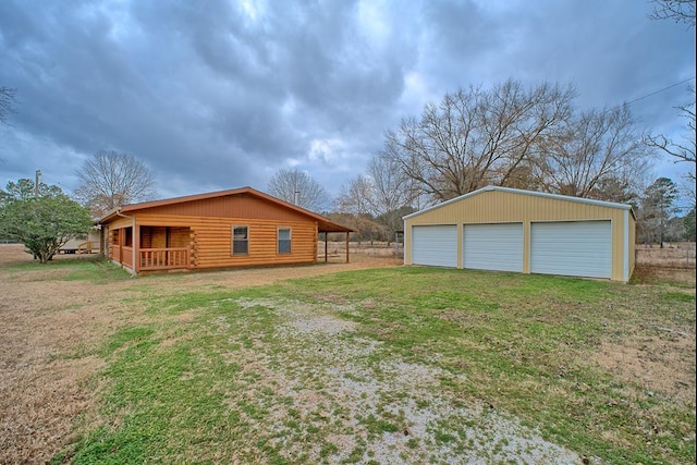 view of side of property with a garage, an outbuilding, a yard, and log siding