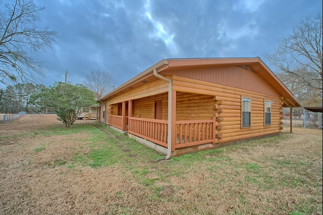 view of side of property featuring a lawn and log exterior