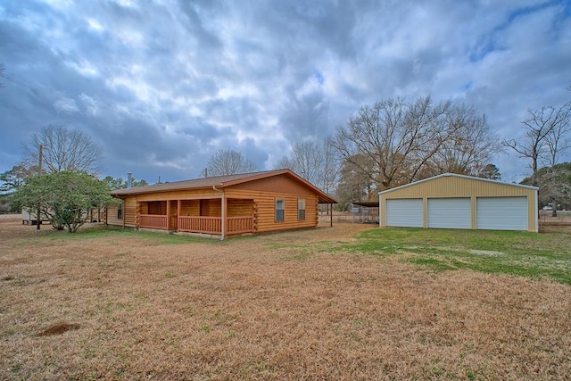 back of property featuring a yard, an outbuilding, a detached garage, and log exterior