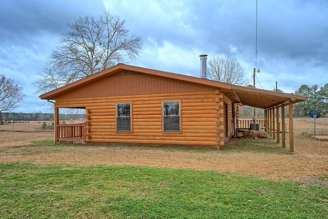 view of home's exterior with log siding and a lawn