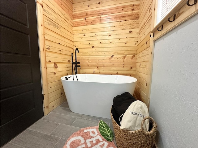 bathroom with wooden walls and a tub