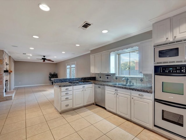 kitchen featuring ceiling fan, sink, stainless steel appliances, white cabinets, and light tile patterned flooring