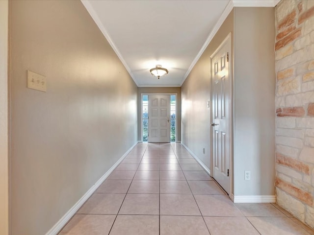 entryway with light tile patterned floors and crown molding