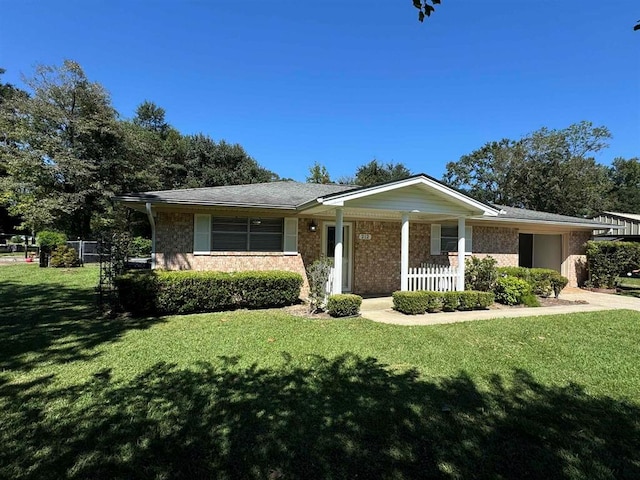 ranch-style home with covered porch and a front yard