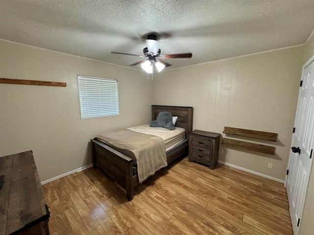 bedroom with ceiling fan, a textured ceiling, and light hardwood / wood-style flooring