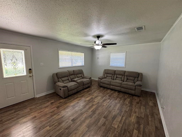 living room featuring a textured ceiling, dark hardwood / wood-style flooring, ceiling fan, and crown molding