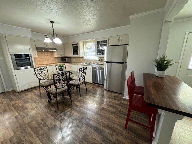 kitchen with sink, dark hardwood / wood-style flooring, pendant lighting, a chandelier, and appliances with stainless steel finishes