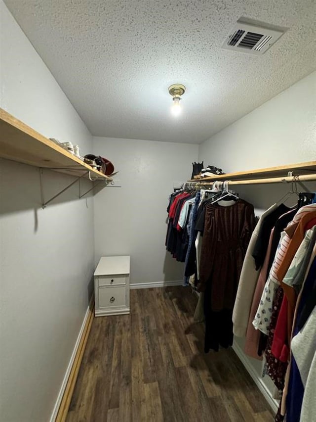 walk in closet with dark hardwood / wood-style floors