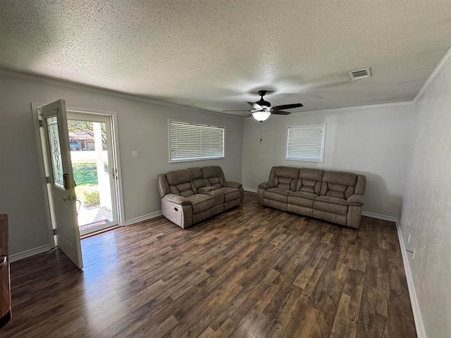 living room with dark hardwood / wood-style floors, crown molding, and a textured ceiling