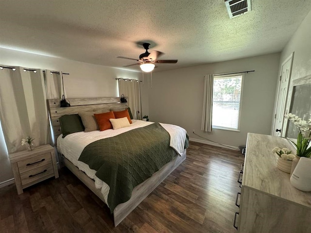 bedroom with a textured ceiling, dark hardwood / wood-style floors, and ceiling fan