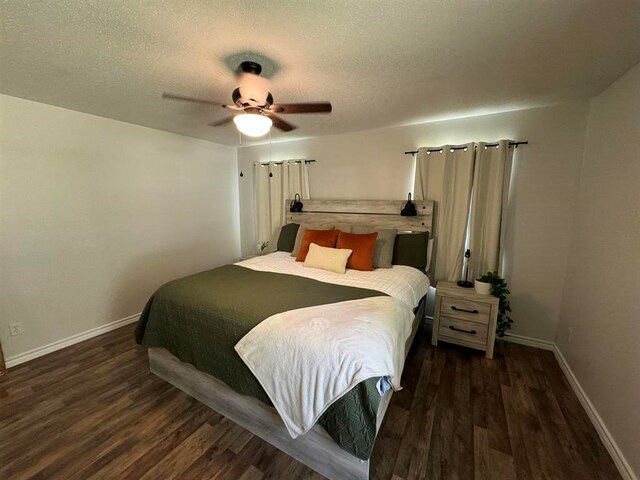 bedroom with ceiling fan, dark wood-type flooring, and a textured ceiling