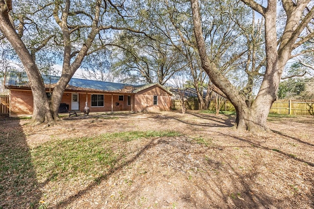 rear view of property with fence and brick siding