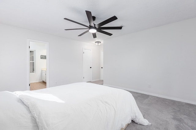 bedroom with light colored carpet, connected bathroom, baseboards, and ceiling fan