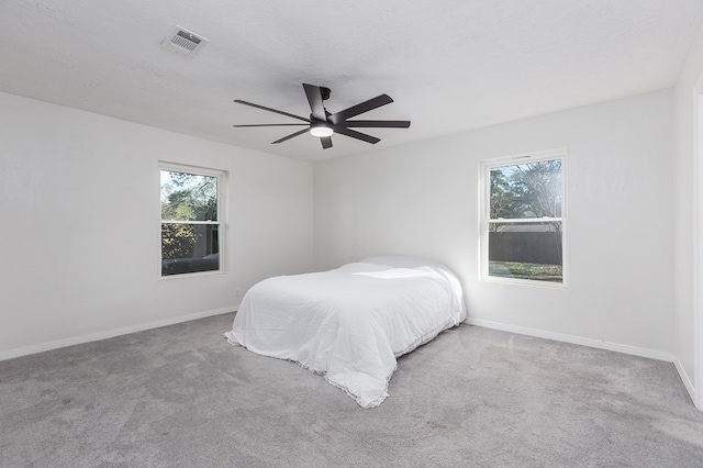 bedroom featuring carpet floors, multiple windows, and visible vents