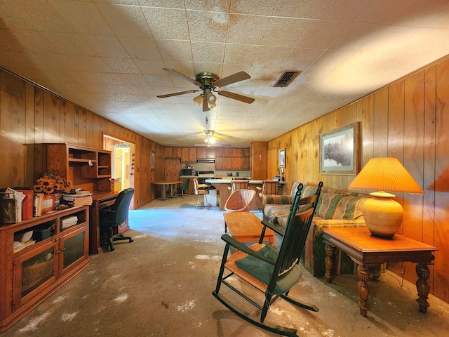 interior space with wood walls and ceiling fan