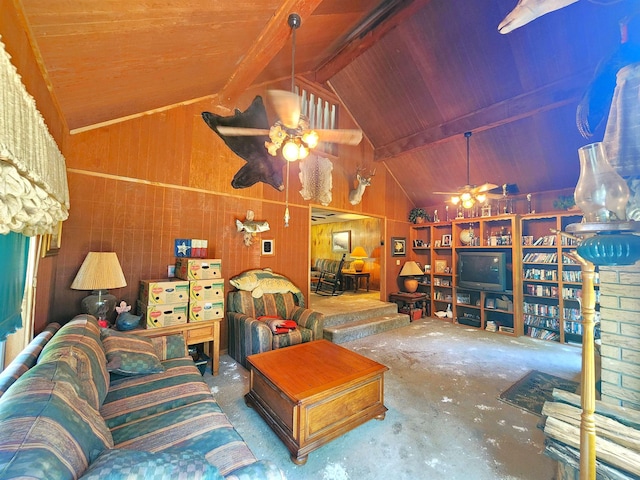 living room with lofted ceiling with beams, ceiling fan, concrete floors, and wood walls