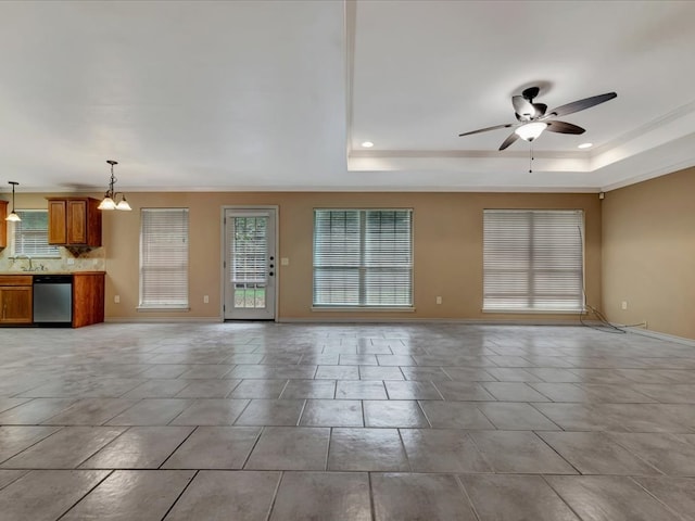 unfurnished living room with ceiling fan with notable chandelier, a tray ceiling, crown molding, and sink