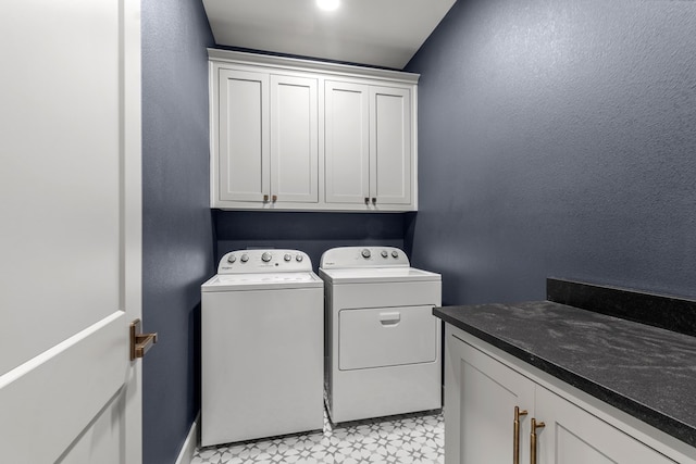 washroom featuring light floors, baseboards, independent washer and dryer, and cabinet space