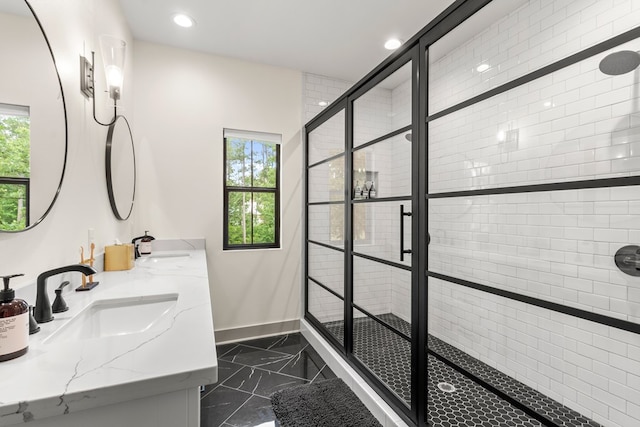 bathroom with plenty of natural light, a shower stall, a sink, baseboards, and marble finish floor