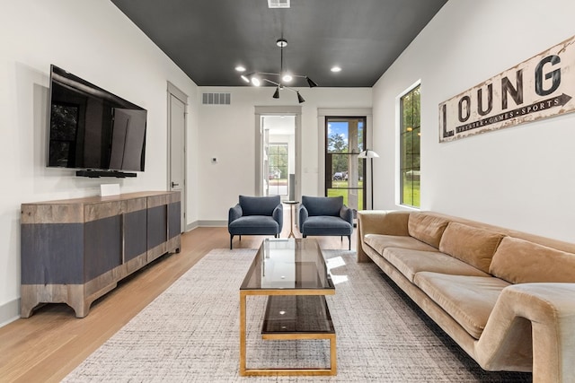 living room featuring recessed lighting, baseboards, light wood-type flooring, and visible vents