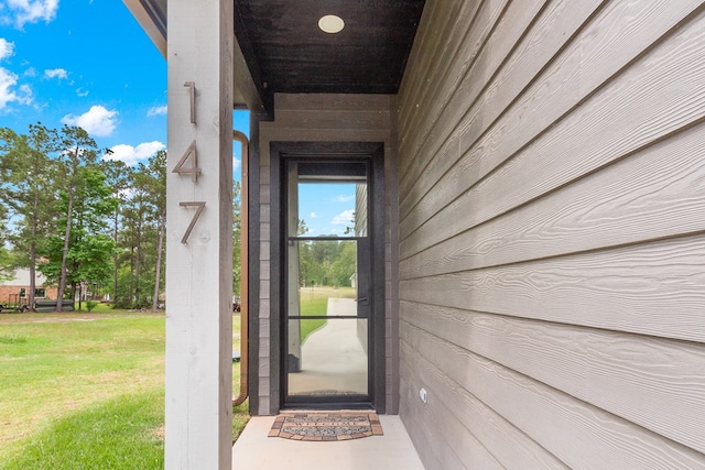 property entrance with a lawn