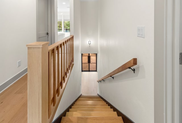 stairway with baseboards and wood finished floors