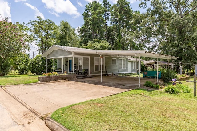 rear view of property featuring a carport, a porch, and a yard