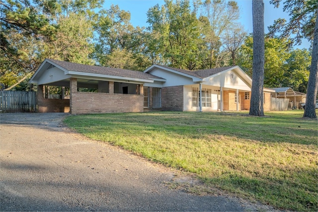 ranch-style house featuring a front yard and a carport