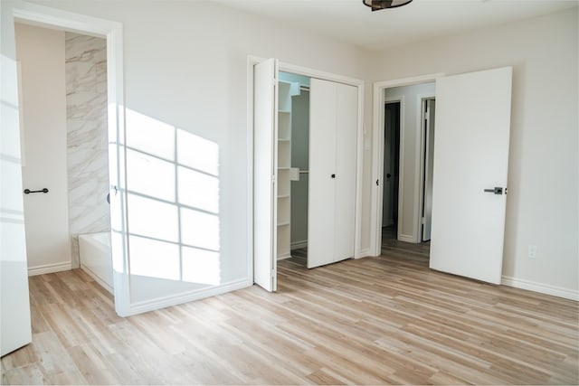 unfurnished bedroom featuring light wood-type flooring and a closet