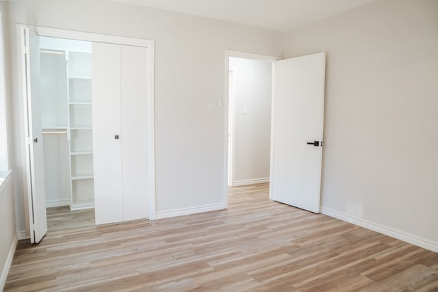 unfurnished bedroom with light wood-type flooring and a closet