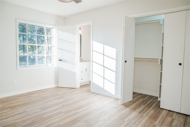 unfurnished bedroom with light hardwood / wood-style floors, a closet, and ensuite bath