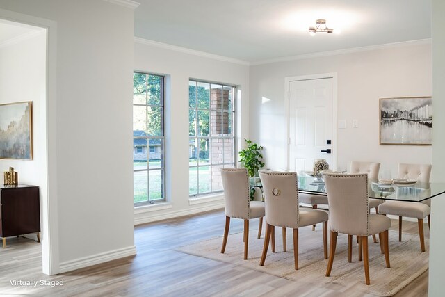 dining area with light wood-type flooring and crown molding