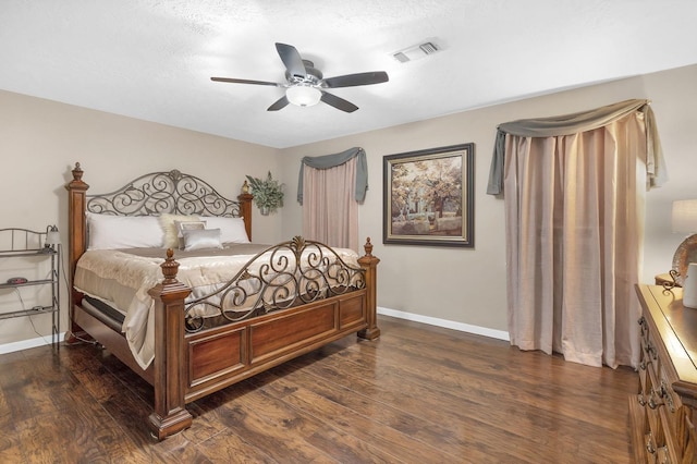 bedroom with a textured ceiling, ceiling fan, and dark wood-type flooring