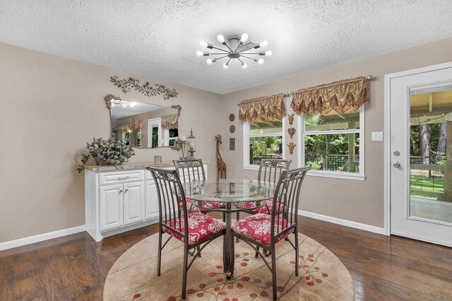 dining space with a textured ceiling, dark wood-type flooring, and a chandelier