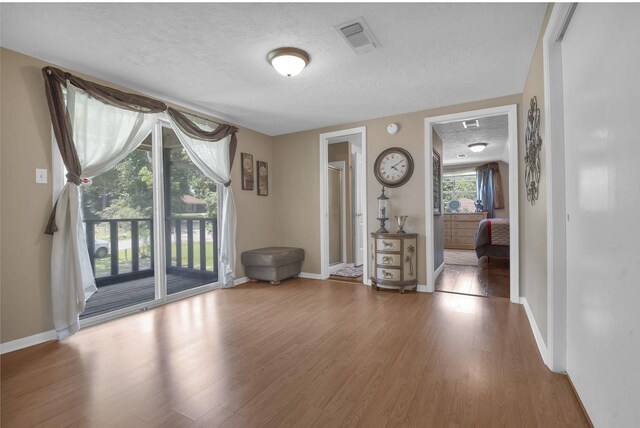 empty room with hardwood / wood-style flooring and a textured ceiling