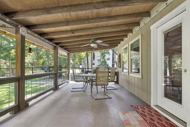 unfurnished sunroom featuring beamed ceiling, a healthy amount of sunlight, and wooden ceiling