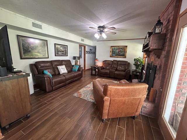 4928 Fm 252, Jasper, TX 75951 - living area with dark wood-style flooring, ceiling fan, a textured ceiling, and a brick fireplace