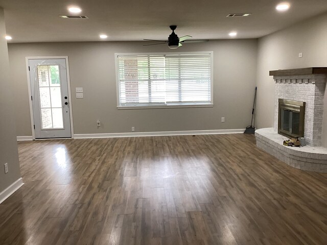 500 Herndon St, Kirbyville, TX 75956 - unfurnished living room with dark wood-type flooring, a brick fireplace, visible vents, ceiling fan, and recessed lighting