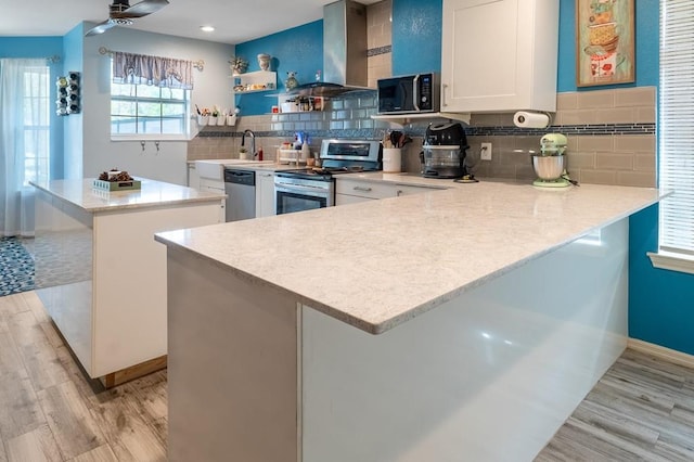 220 Casey Rd, Lufkin, TX 75901 - kitchen with stainless steel appliances, exhaust hood, open shelves, a peninsula, and light wood-style floors